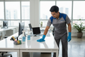 Office cleaning worker cleaning desk
